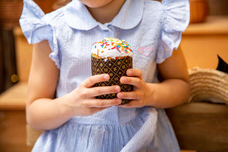 Easter holiday. a cake in the hands of a girl in a blue dress. close up.の写真素材