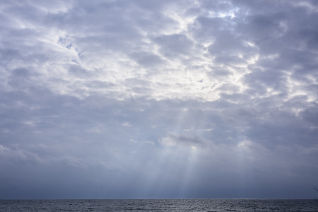 Glowing clouds in sky with rays of sunshine over Lake Ontarioの写真素材