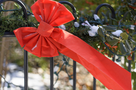 christmas red ribbon decorative bowtie with snow swinging in the windの写真素材