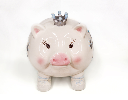 cute cartoon ceramic piggy bank wearing a crown on white.の写真素材