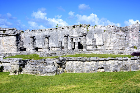 Ancient Mayan building ruins against blue sky in Tulum, Mexicoの写真素材