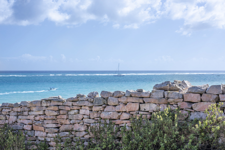 the Caribbean Sea in Tulum, Yucatan Peninsula, Mexico, with old brick walls and green grass in the foregroundの写真素材