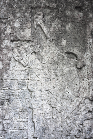 closeup detail of ancient weathered stone stele carving with fading image of a Maya king at Grupo Macanxoc Mayan Coba Ruins Yucatan Mexicoの写真素材