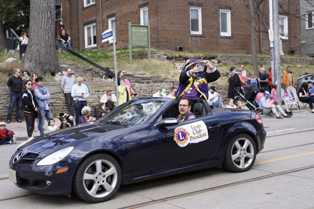 the Lions Club president greets viewers along Queen Street East Toronto in the Beaches Easter Parade 2017.のeditorial素材