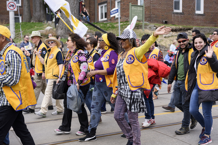 people march along Queen Street East and wave to viewers in the Beaches Easter Parade 2017.のeditorial素材