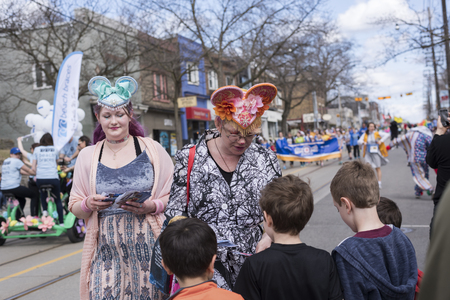 women in Easter costume distribute gifts to children along the Queen Street East in the Beaches Easter Parade 2017.のeditorial素材