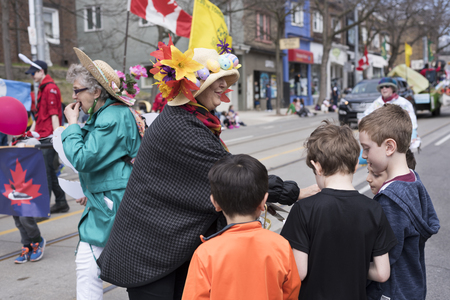 woman in Easter costume distributes gifts to children along the Queen Street East in the Beaches Easter Parade 2017.のeditorial素材