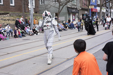 the Star Wars character Stormtrooper Pilot waves to children along the Queen St E Toronto during the Beaches Easter Parade 2017のeditorial素材