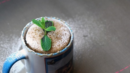 Quick dessert - cake in a mug decorated with mint and sugar powderの写真素材