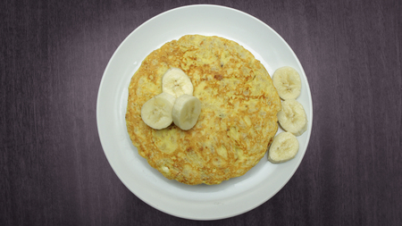 Healthy Pancakes with Banana Slices on White Plate on Wooden Tableの写真素材