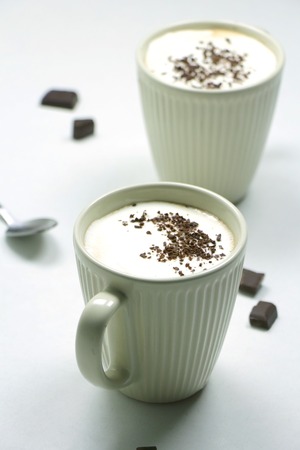 Homemade Hot Chocolate Drink topped with Whipped Cream and Grated Chocolate in a White Mug on a White Backgroundの写真素材