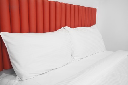 Bed with headboard and pillows in a hotel roomの写真素材