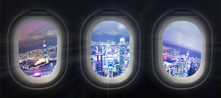 Composite image of city at night through airplane windowの写真素材