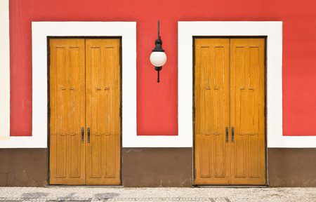 Front view of two doors against red wallの写真素材
