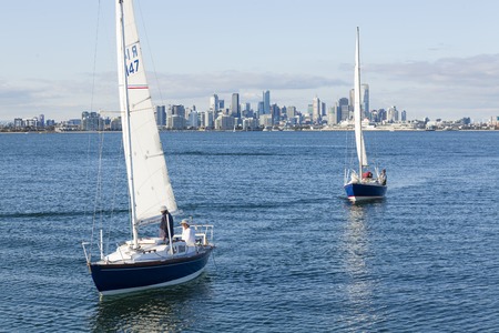 Melbourne, Australia - Sep 5, 2015: Two sailboats sailing across the sea with Melbourne CBD in the backgroundのeditorial素材