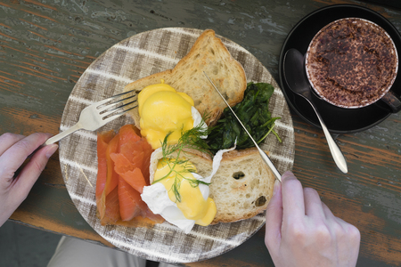 Top down view of eathing healthy breakfast with salmon, egg, bread and spinachの写真素材