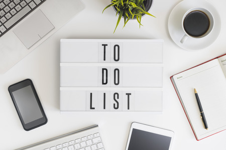 To do list words on office table with computer, coffee, notepad, smartphone and digital tabletの写真素材