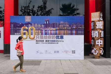 Property buyer walking pass real estate advertisement in Chinaのeditorial素材