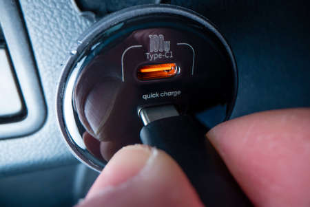 Close-up view of plugging in USB type C cable into a powerful car charger, shot with macro probe...