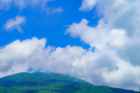 Clouds in the blue sky over the mountain. Nature background.の写真素材