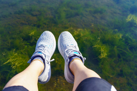 a person who throws one's feet out of a pond and sitsの写真素材