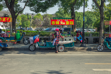 Shanghai, China. 31.10.2016 Peoples, Tuk-tuk, urban street, cars, markets. Old and modern buildings. Peoples walk and cars drive. Travel photo.のeditorial素材