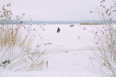 Riga, Latvia, fisherman. Winter, snow and frozen lake. Snow an ice, trees and fresh air. Travel photo 2016.の写真素材