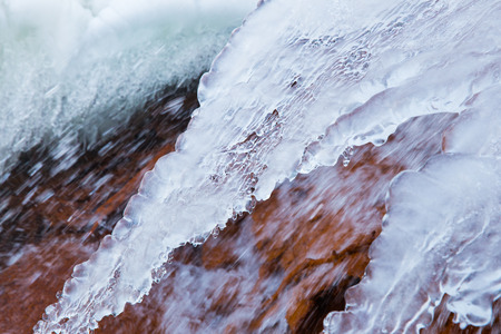 Cesis, Latvia. Red rock waterfall and ice at Latvia. Travel photo. 2018