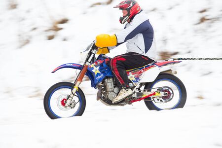 City Cesis, Latvia, Winter motocross, Driver with motorcycle and skier. Travel photo. 2018 Fast...