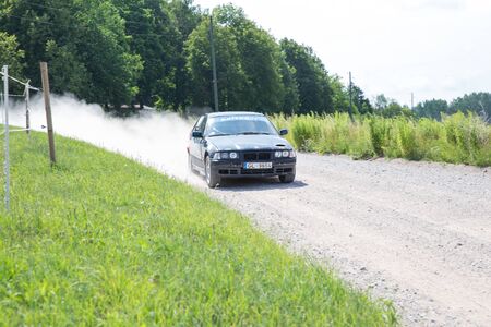 City Livi, Latvia. Amateur rally, dirt road, car with rider. Speed and dust. Travel photo 2018のeditorial素材