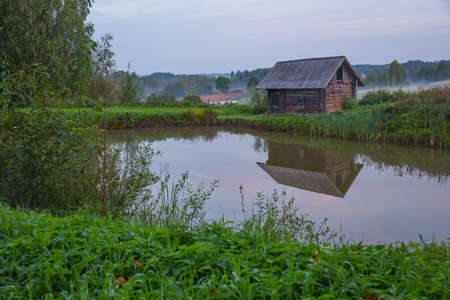 City Kraslava, Latvia. Bath house at early morning, green grass and lights. Water and nature.
