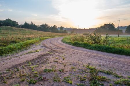 City of Kraslava, Latvia. Early morning with sunlight, meadow, trees and fog. Nature photo.の写真素材