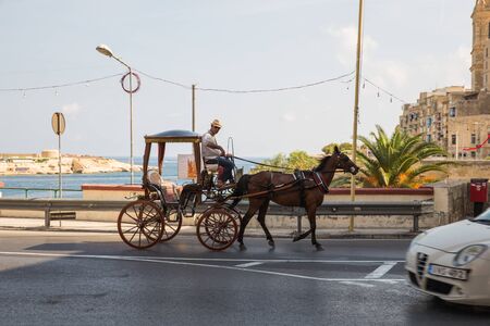 City Valleta, Malta, Europe. Horse at city street and urban view. Cars, peoples and architecture....