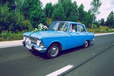 City Cesis, Latvia. Just merried, retro blue car with driver. Nature and way. Travel photo 2018. Love and romance.のeditorial素材