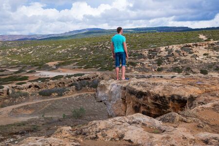 City Paphos, Cyprus. On the cliff stay boy. Big hills and sky. Travel photo 2018 december.のeditorial素材
