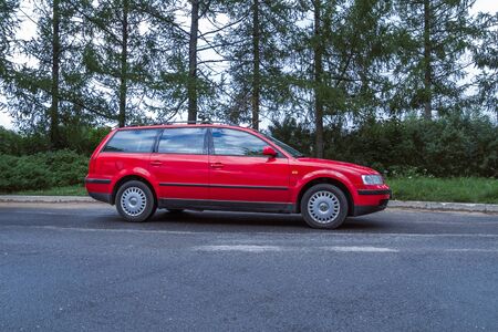 City Cesis, Latvia. Red Wolksvagen Passat B5 to street, trees an way. Travel photo 2012.