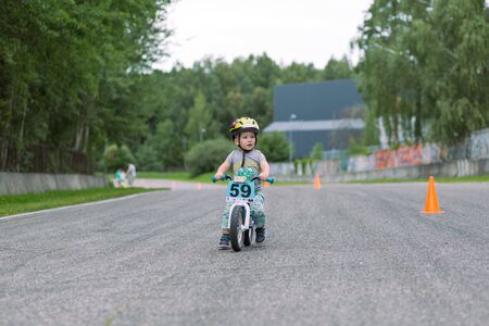 City Riga, Latvian republic. Toddlers train and ride bikes. Mini safe driving instruction for children. Urban city view. 19 Aug. 2019のeditorial素材