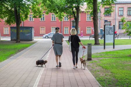 City Riga, Latvian Republic. Women walk in the park with dogs. 2019. 11. Jun.のeditorial素材