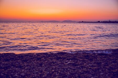 Greek Republic. Sunshine in sea and swimming people. In the distance mountains and sky. 17. Sep....