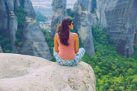 City Meteora, Greek Republic. Big mountains and girl sit on rock. 12. Sep. 2019. Travel photo.の写真素材