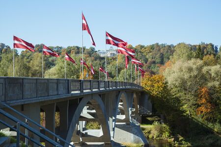 City Sigulda, Latvia Republic. River and bridge with flags in Autumn. 27. Sep. 2019のeditorial素材