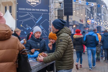 City Riga, Latvia. Street Restaurant food festival. Man tastes the food.18.01.2020のeditorial素材