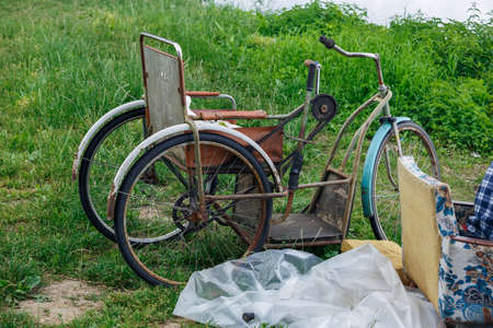 City Plavinas, Latvia. Old rusty disabled bike and green grass on the river.18.07.2020の写真素材