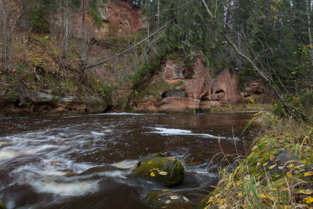 City Cesis, Latvia. Rapid river with stones and trees. Natural flora.Travel photo. 31.10.2020の写真素材