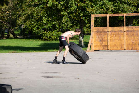 City Liepaja,Latvia.The man is lifting a heavy tire.19.09.2020のeditorial素材