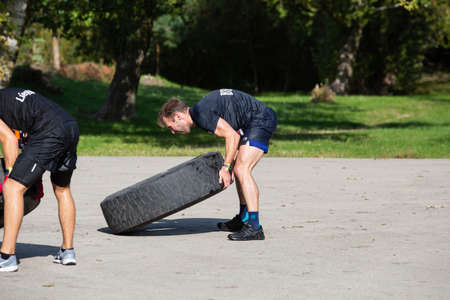 City Liepaja,Latvia.The man is lifting a heavy tire.19.09.2020のeditorial素材