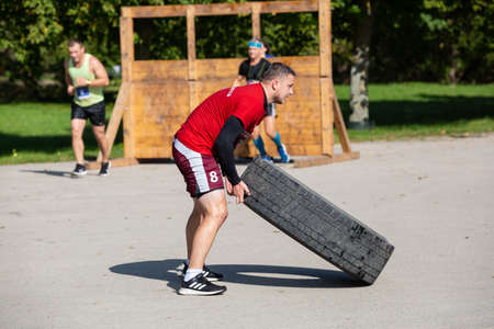City Liepaja,Latvia.The man is lifting a heavy tire.19.09.2020のeditorial素材