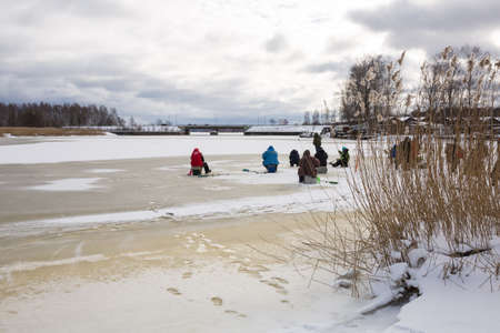 City Riga, Latvia. Frozen river and anglers fishing fish.Travel photo 14.02.2021のeditorial素材