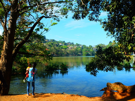 A woman with baby enjoying the lake viewの写真素材