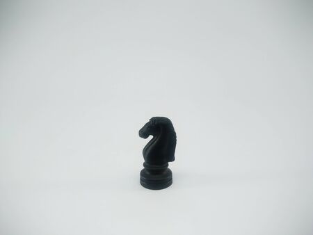 Black plastic knight chess piece isolated on a white backgroundの写真素材